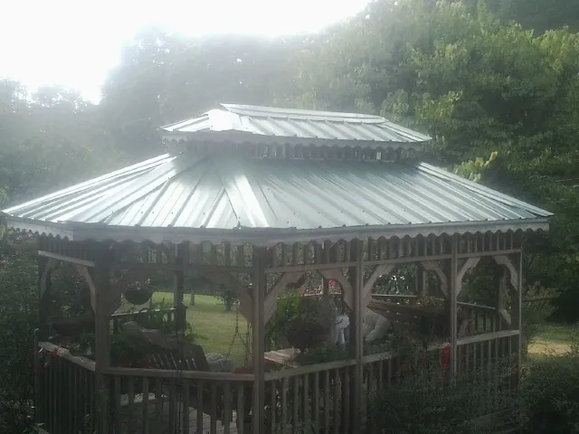 Two tier green metal roof on a garden gazebo in Cinebar