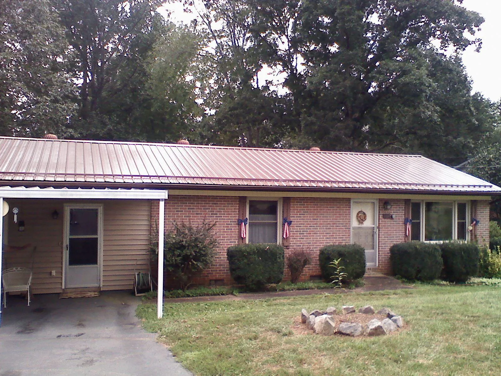 Bronze metal roof and carport on a brick ranch home — Roof Repair work by our crew in Cinebar